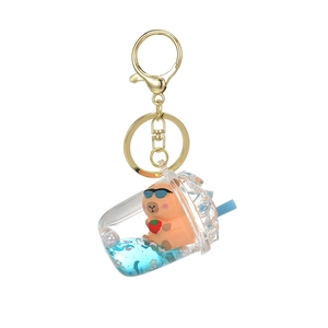 Capybara quicksand keychain featuring a mini milk tea cup with blue liquid and gold ring