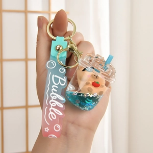 Detail of Capybara bubble tea keychain with blue liquid glitter and a small bear inside