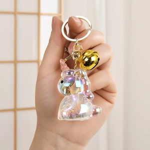 Macro detail of iridescent unicorn keychain with gold bell and sparkling glitter finish
