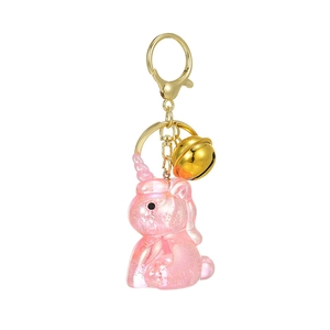 Pink translucent unicorn keychain with gold bell and glitter resin finish for backpacks