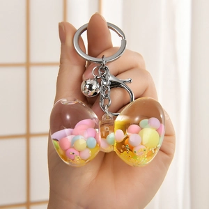 Handheld bow-shaped liquid keychain with colorful matte beads and silver bell detail