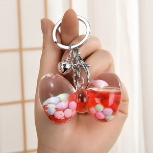 Creative bow-shaped liquid quicksand keychain with red beads and silver bell charm