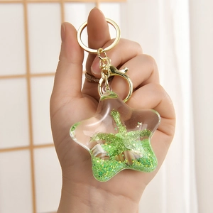 Detail eines sternförmigen Schlüsselanhängers mit grünen Pailletten und Mini-Palme