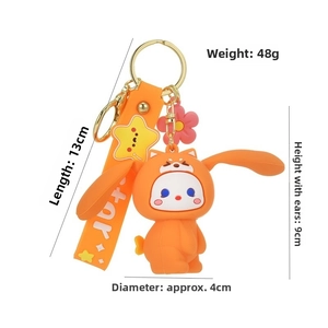 Detail of creative orange rabbit keychain with star strap and cute shiba inu hoodie charm