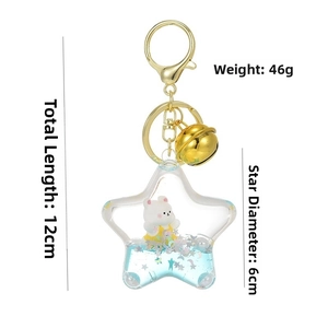 Detailed view of a star-shaped liquid keyring with a cartoon bear and gold bell