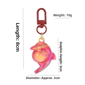 Detail view of pink gradient dolphin keychain with measurements and red lobster clasp