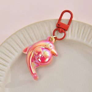 Detail of a pink and orange gradient dolphin pendant with a red lobster clasp