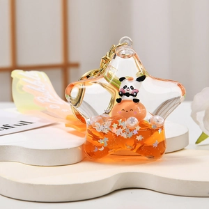 Detail of star-shaped liquid keychain with cartoon panda and golden sequins