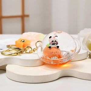 Detail of creative panda floating keychain with liquid quicksand and golden metal ring