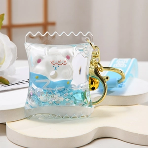 Acrylic liquid keychain with white bear and blue sequins inside a candy bag shape
