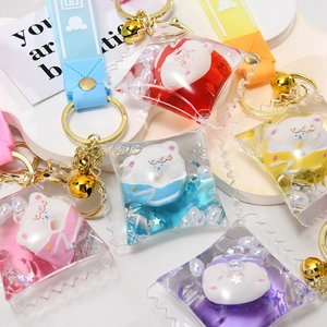 Close-up of colorful bear liquid sand keychains in candy bag style with gold bell charms