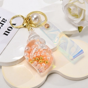Macro view of shell keychain with iridescent PVC strap and pink inner pearls
