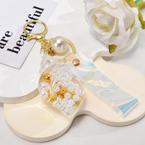 Creative conch keychain with pearls and holographic strap on a white background