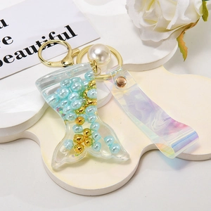 Macro shot of liquid quicksand mermaid tail pendant with pearls and colorful wrist strap