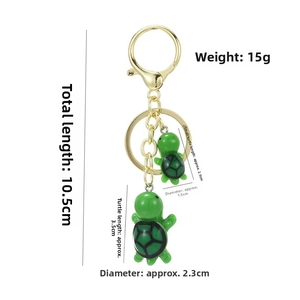 Detailed view of twin green turtle keychains with size dimensions in centimeters