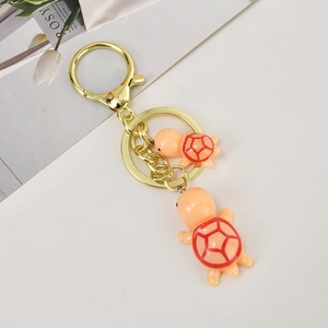 Detail of cute orange turtle double keychain with golden metal ring and lobster clasp