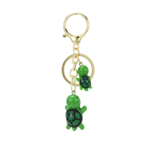 Creative green turtle keychain with golden metal lobster clasp on white background