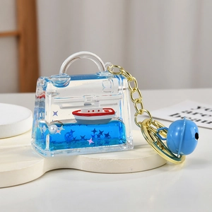 Blue liquid handbag keychain with floating ship, star sequins and a blue bell charm