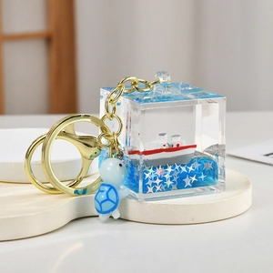 Detailed macro view of the blue nautical sailboat cube keychain with a turtle pendant