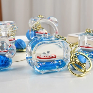 Macro detail of nautical liquid keychain with floating ship and gold lobster clasp
