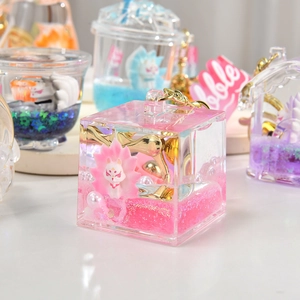 Macro shot of pink liquid quicksand acrylic keychain with white fox and gold clasp