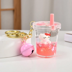 Detail of pink liquid kitty keychain with glitter sequins and gold bell accessory