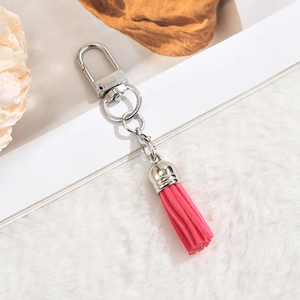 Detailed macro view of a pink suede tassel keychain with polished silver metal hardware