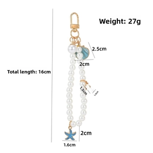 Detail of sea theme pearl keychain featuring blue enamel shell and starfish charms
