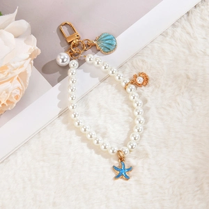 Detail of nautical pearl keychain with blue enamel starfish and shell charms