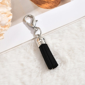 Silver lobster clasp with black suede tassel pendant on white plush background