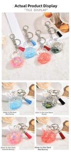 Detailed view of rabbit acrylic oil-filled keychains with tassels and glitter stars