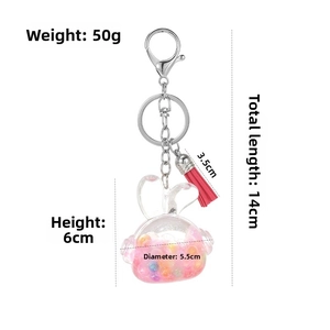 Detail view of rabbit oil bottle keychain with size metrics and red tassel accent