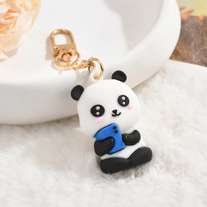 Close-up of a cute cartoon panda keychain holding a blue phone on white plush background