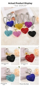 Close-up of sparkling rhinestone heart keychains in various colors on plush fabric