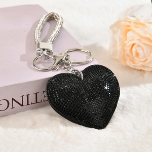 Macro view of heart-shaped black rhinestone keychain with silver buckle and braided strap