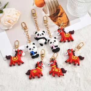 Set of 8 cute cartoon panda and red zodiac horse silicone keychains on a white soft surface