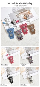 Gros plan de porte-clés ours en strass brillants avec pompons colorés et clochettes