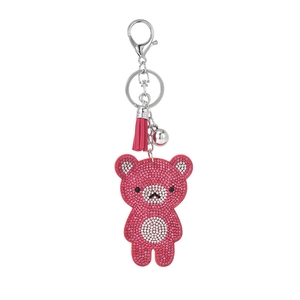 Porte-clés ours en strass rose avec pompon et clochette sur fond blanc