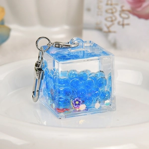 Luminous square acrylic keychain with blue beads and purple flower sequins in flowing oil