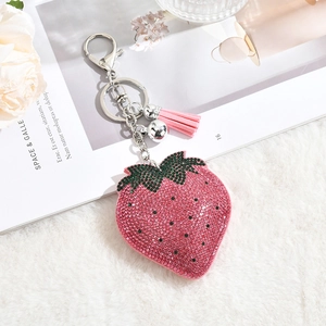 Close-up of strawberry keychain with pink rhinestones, leather tassel and silver clasp