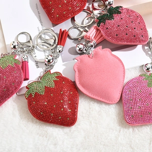 Close-up of strawberry rhinestone keychain with luxury tassels and lobster clasp detail