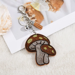 Detailed view of mushroom keychain with brown rhinestones and gold lobster clasp