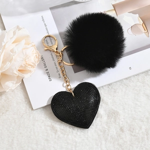 Detail of fluffy black plush heart keychain with sparkling rhinestone pendant and gold hook
