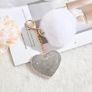 White faux fur pompom keychain with sparkling rhinestone heart charm and gold hardware