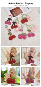 Close-up of sparkly cherry keychains with rhinestones and tassels in various colors