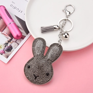 Detailed view of rhinestone rabbit keychain with grey tassel and silver metal bell