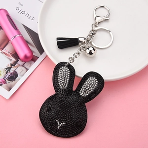 Detail of black rabbit keychain with rhinestones, leather tassel, and small bell charm
