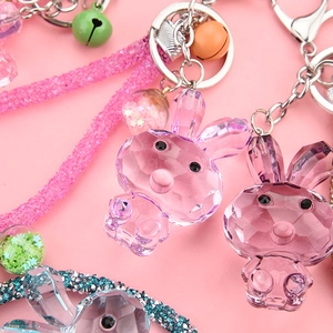 Macro shot of colorful faceted acrylic bunny keychains with glittering rope and silver bells