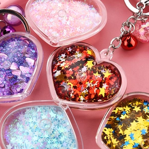 Acrylic heart keychain with liquid glitter, star sequins and a colorful bell charm
