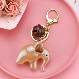 Close-up of cute beige acrylic elephant keychain with heart ear and small brown bell